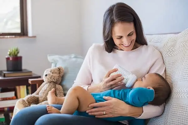 mother feeding child infant formula